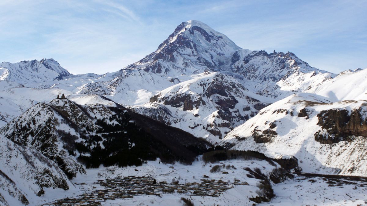 Kasbek (5041m) und die Gergetier Dreifaltigkeitskirche auf der linken Seite.