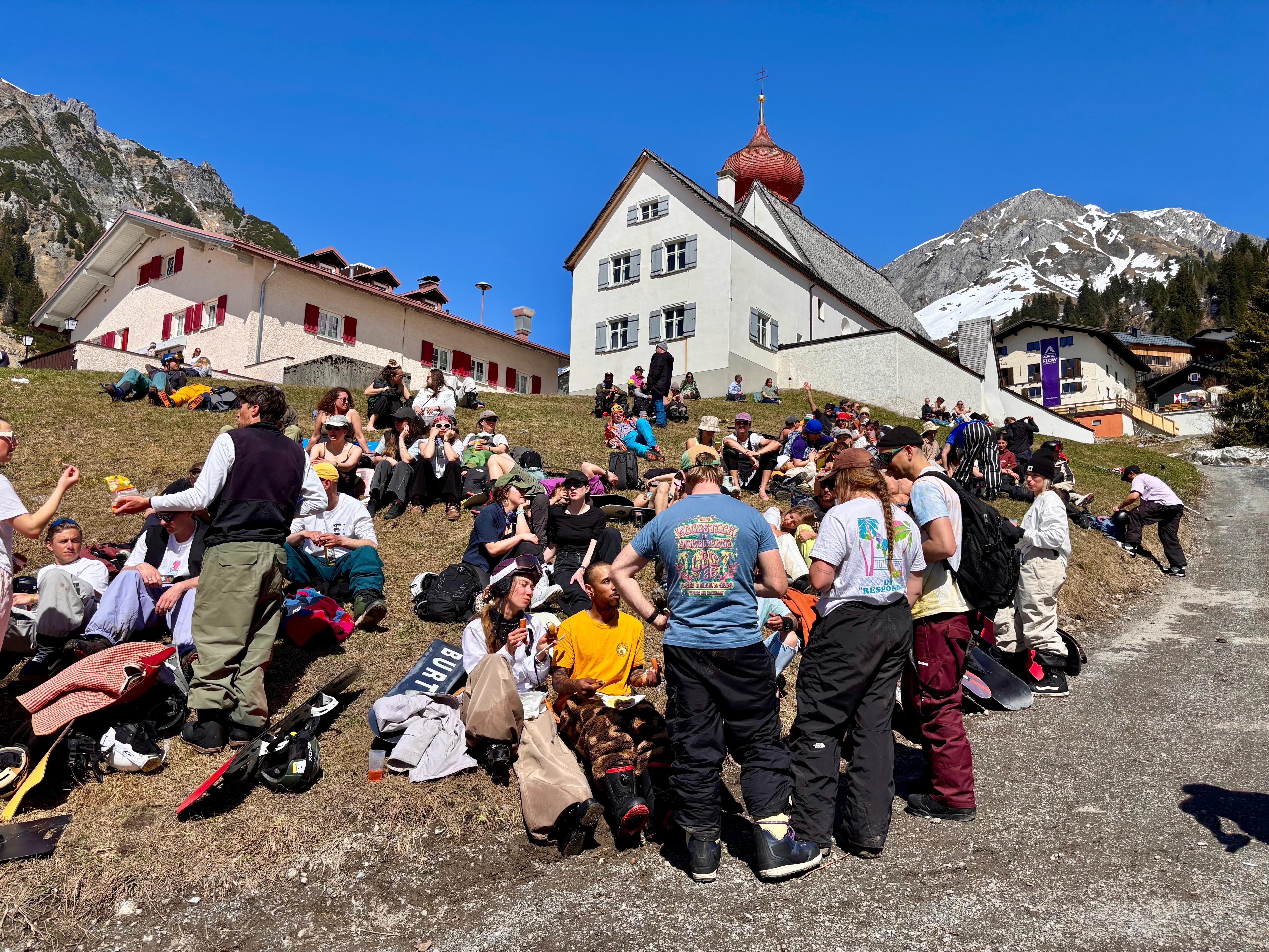 Crowd entspannt auf der Wiese vor der Stuben Kapelle in der Sonne