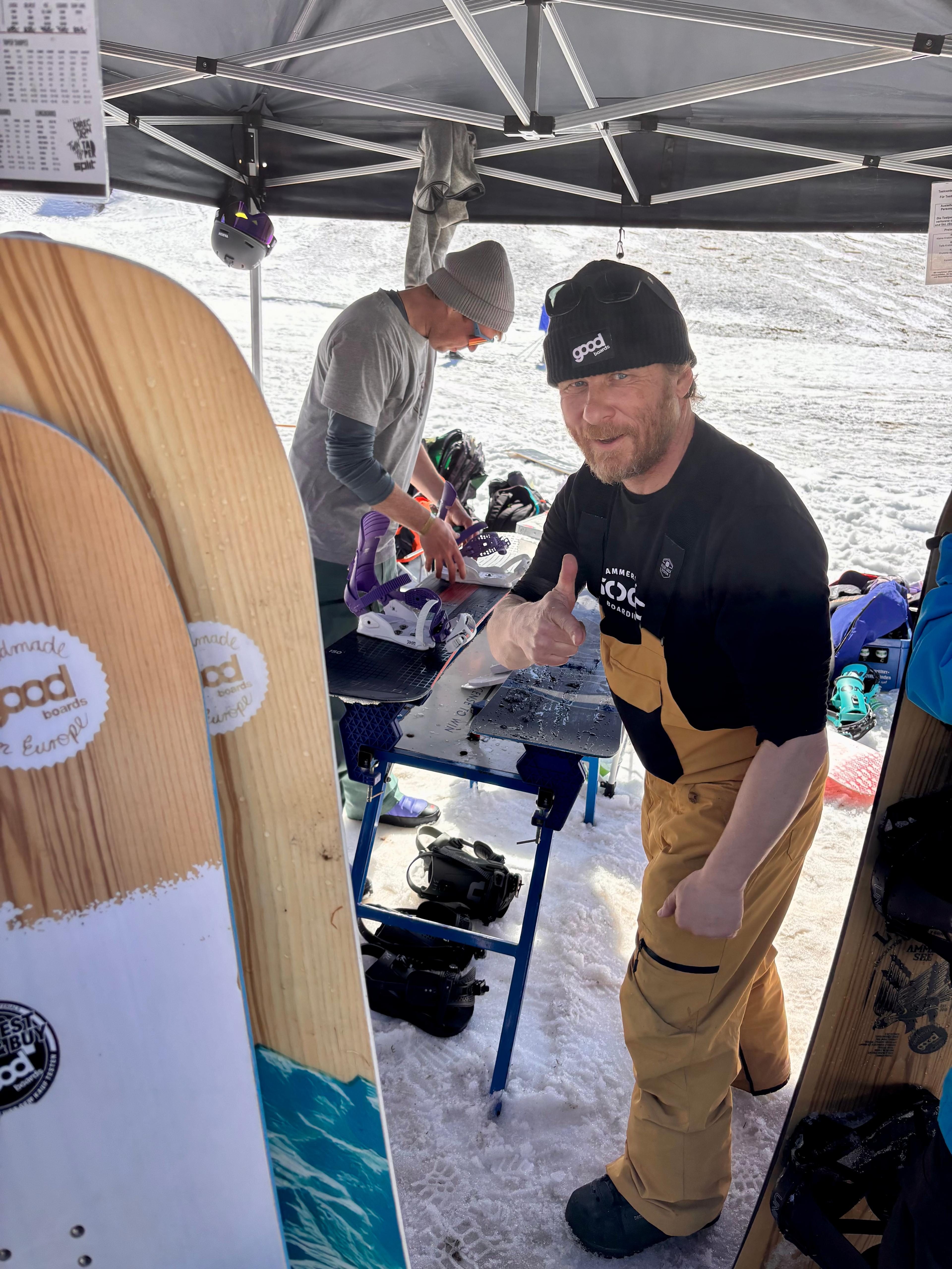 Mann mit Goodboards Board gibt Daumen hoch am Marken-Stand