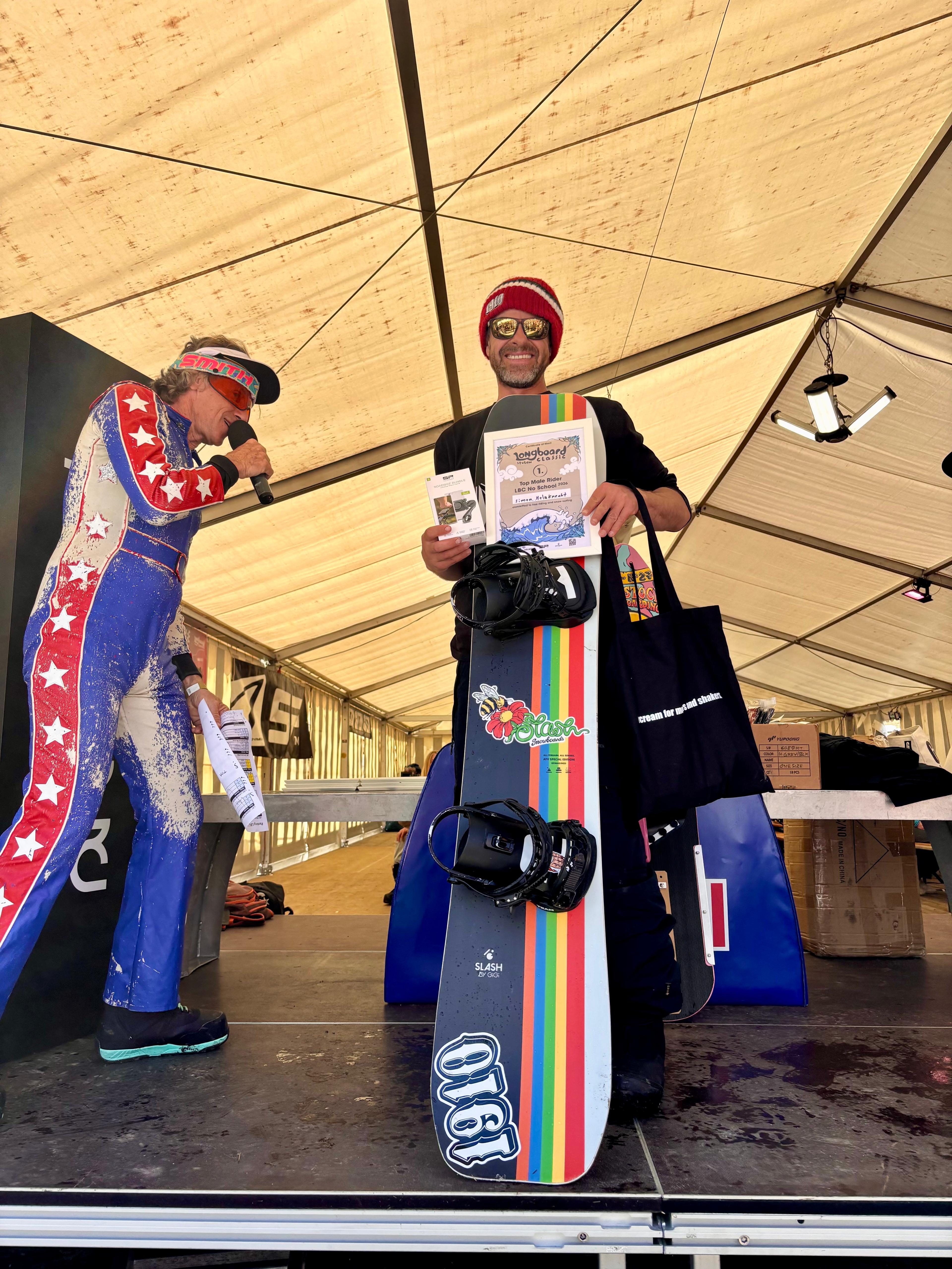 Sonderpreis-Gewinner auf der Bühne mit buntem Regenbogen-Vintage-Snowboard
